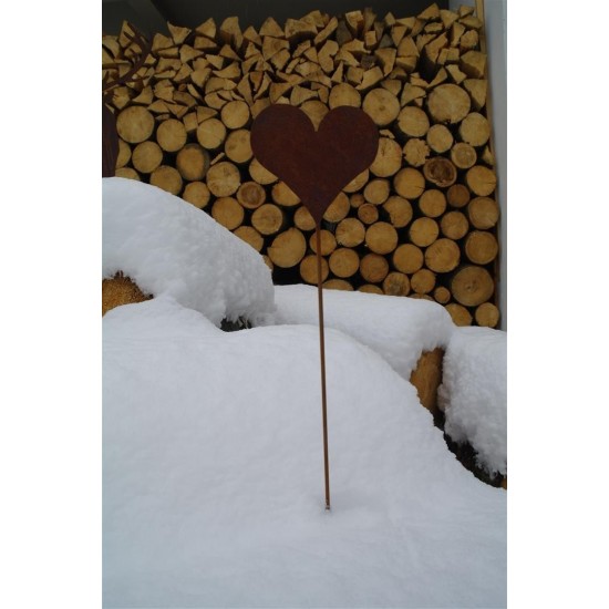 Herz Gartenstecker als Winterdeko im Schnee vor einem Holzstapel