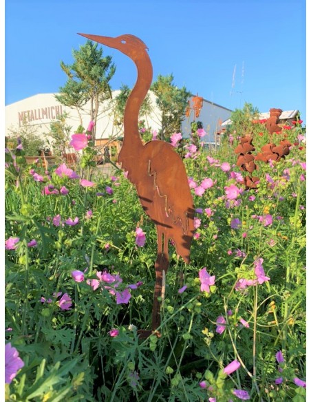 Stehender Reiher im Blumenbeet vor der Blüte