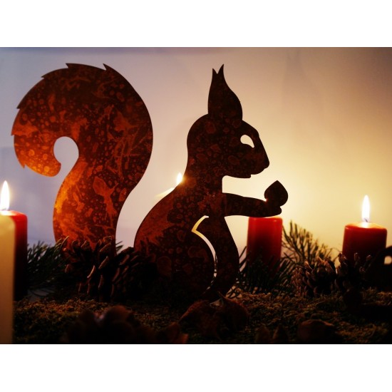 Edelrost Eichhörnchen mit Nuß in der Hand auf Platte