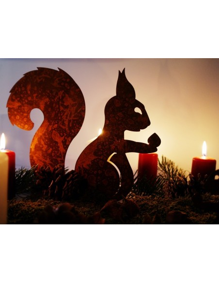 Edelrost Eichhörnchen mit Nuß in der Hand auf Platte