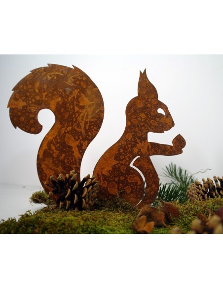 Edelrost Eichhörnchen mit Nuß in der Hand auf Platte