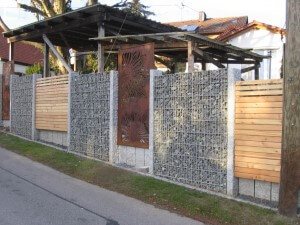 In einer Gabione und Granitsäule eingefasste Sichtschutzwand aus Metall